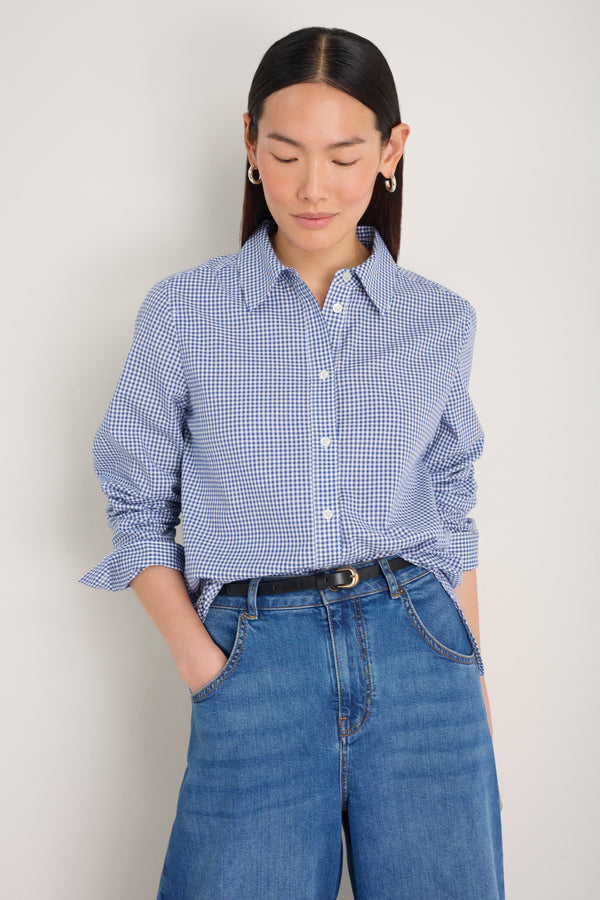 Model wearing a midnight blue gingham shirt tucked into dark denim