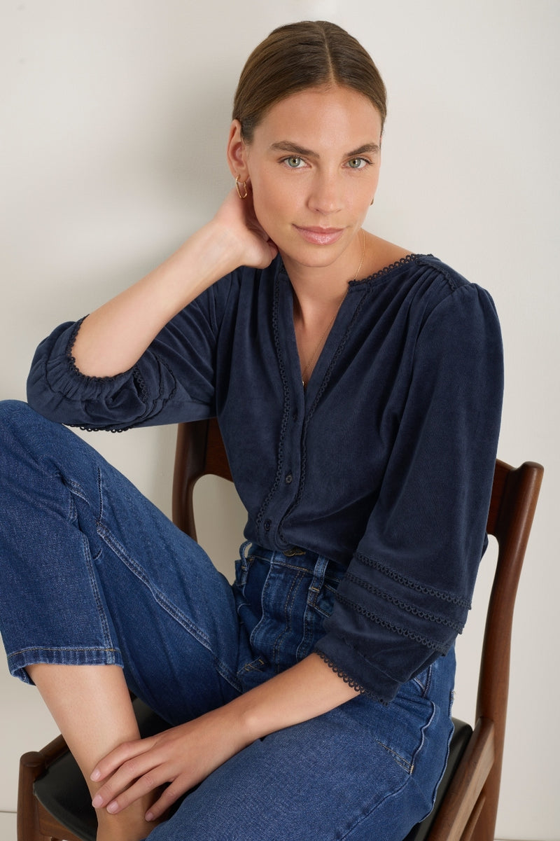 Woman sitting in Velma midnight velour blouse